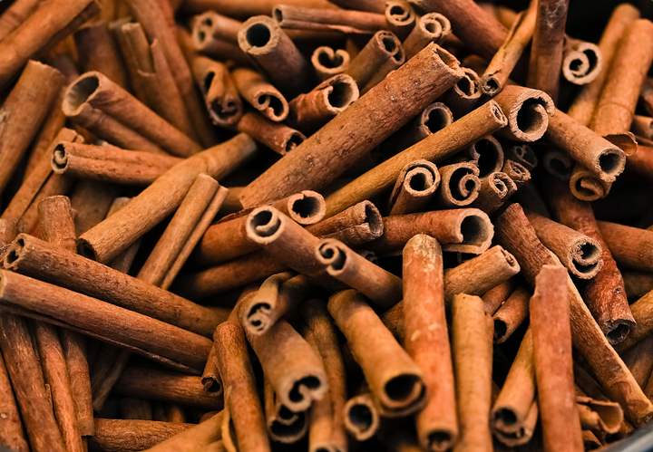 A pile of cinnamon sticks closely arranged.